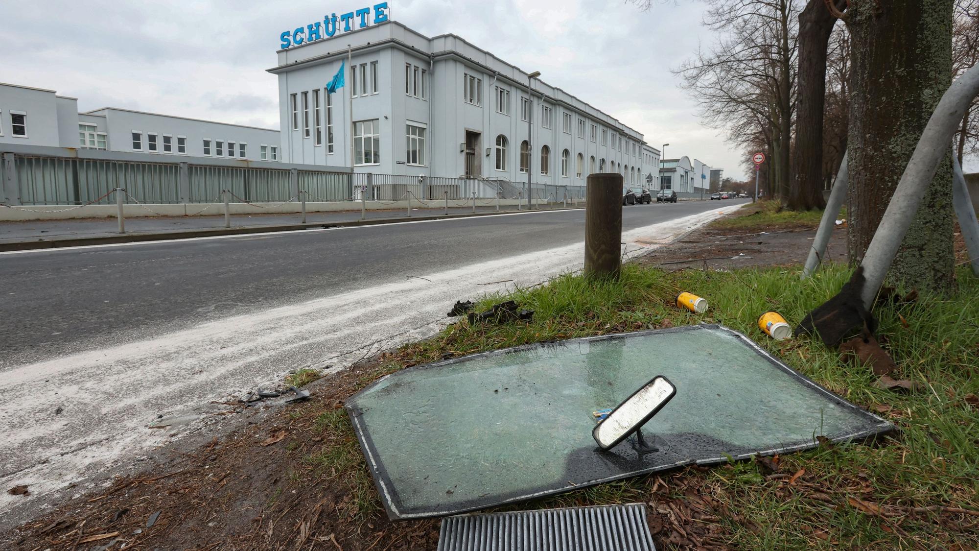 An der Unfallstelle auf der Alfred-Schütte-Allee auf der Höhe der Schütte Werke liegen Fahrzeugteile der beim Unfall beschädigten Autos.