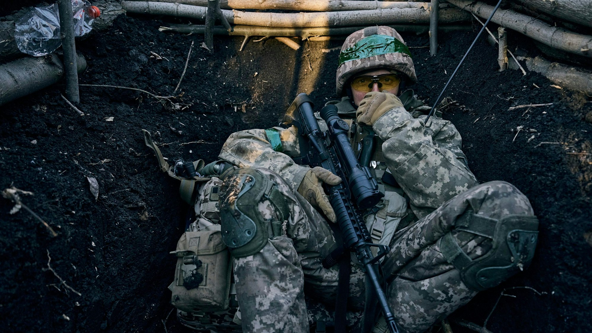 Ein ukrainischer Soldat sitzt in einem Graben in der Nähe russischer Stellungen bei Bachmut.