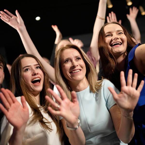 Mitglieder der Reformpartei und Anhänger von Ministerpräsidentin Kaja Kallas posieren für ein Bild. Sie haben die Hände erhoben und lächeln.