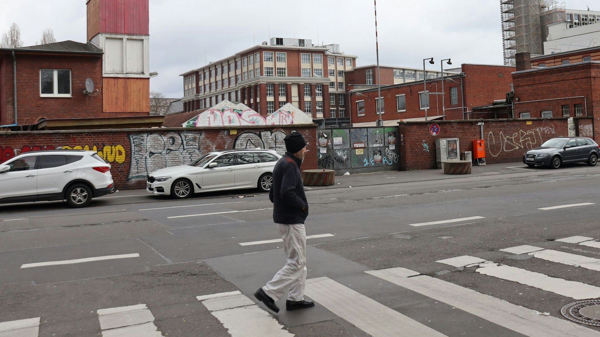 Fußgänger und geparkte Autos vor dem ehemaligen Kölner Güterbahnhof.