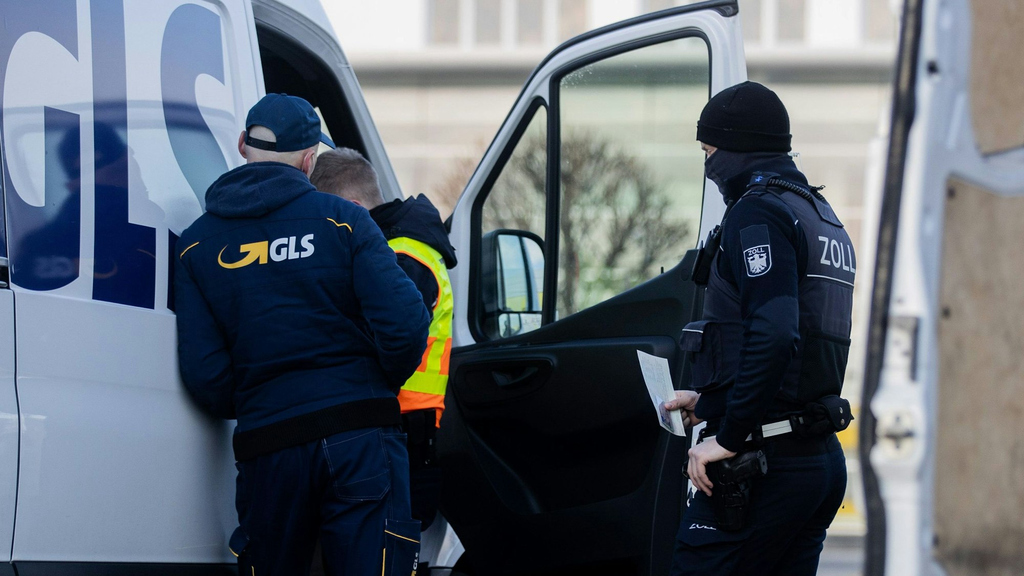 Ein Zollbeamter kontrolliert ein Auslieferungsfahrzeug von GLS. Überprüft wird der Zustand des Lieferwagens.