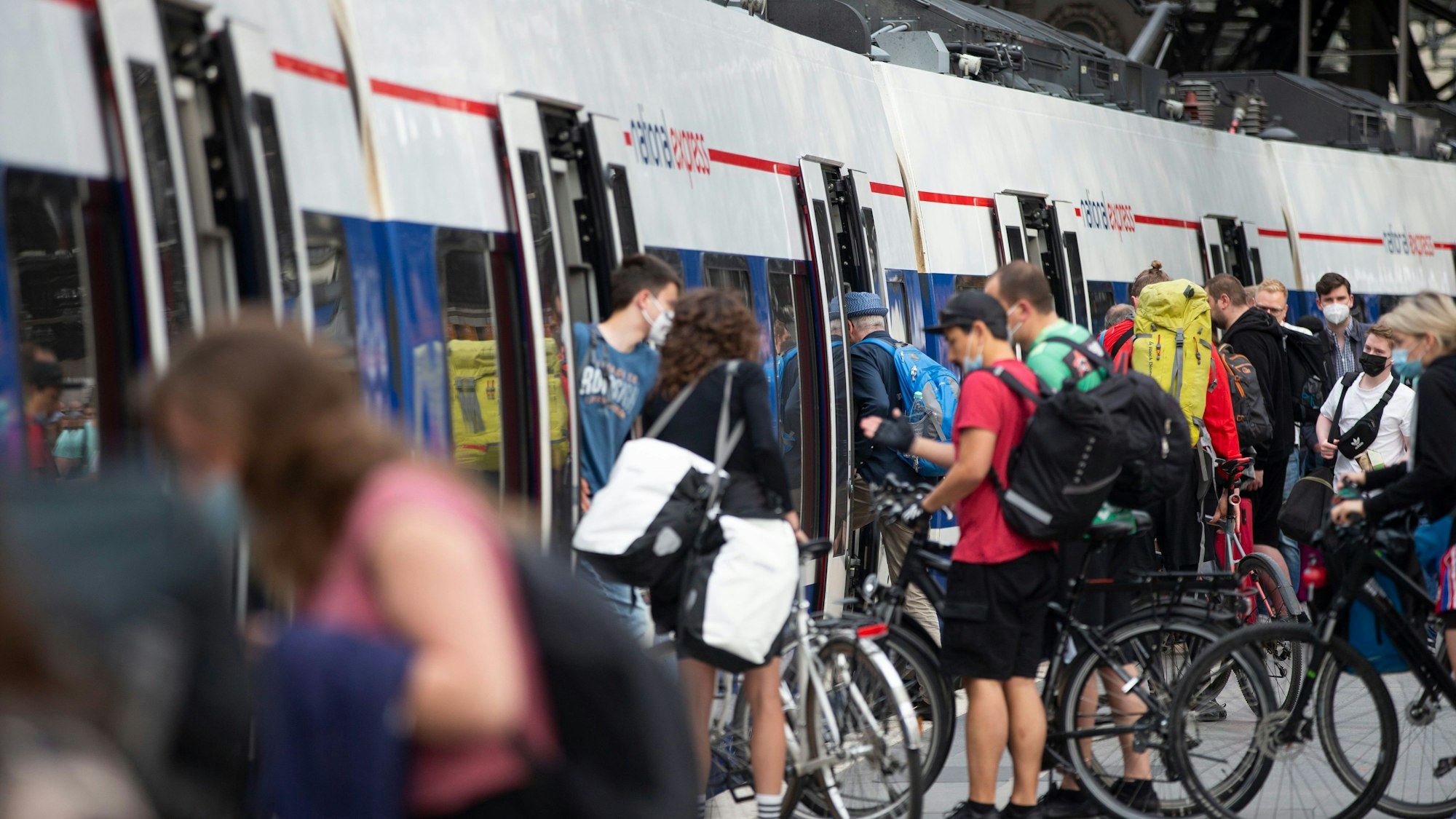 Reisende steigen am Kölner Hauptbahnhof in einen Zug.