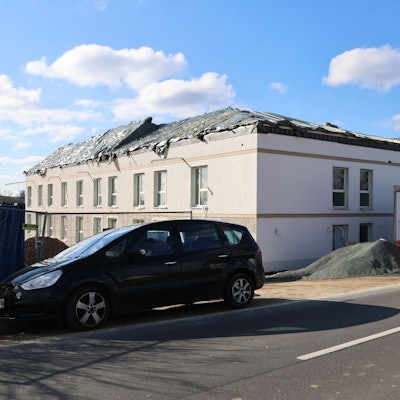 Ein unfertiges Haus im Bau, mit Plane auf dem Dach.