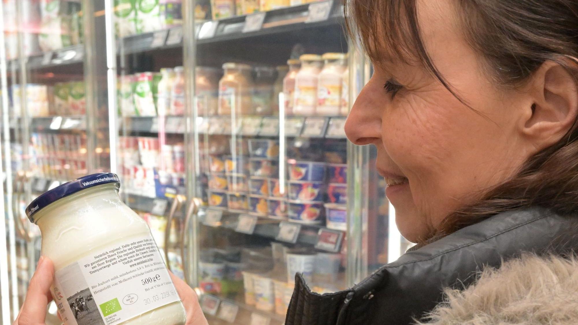 Die Ernährungsberaterin liest die Inhaltsstoffe eines Joghurts.