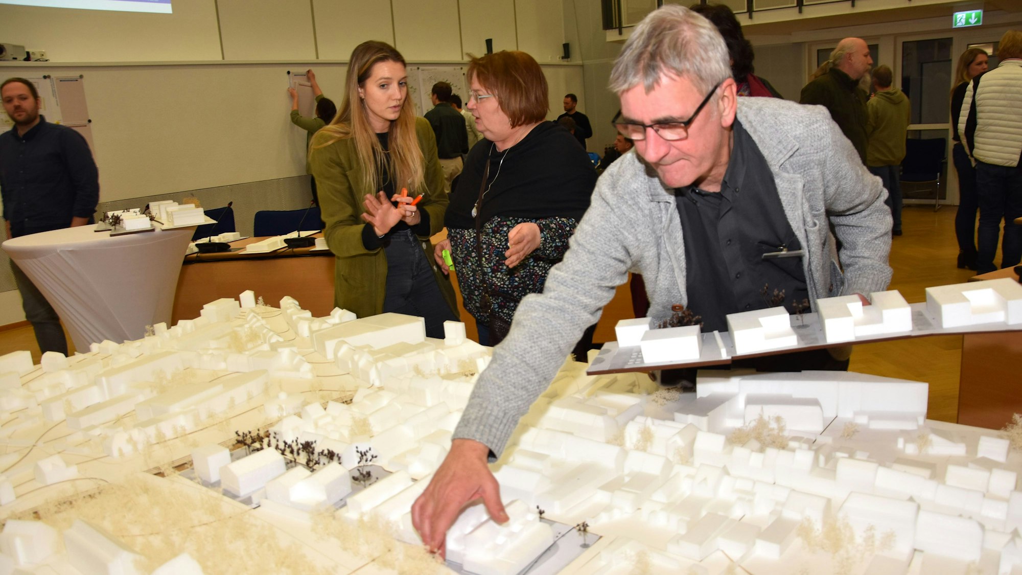 Man sieht Welters, wie er Modellhäuser zu einem größeren Modell hinzufügt.