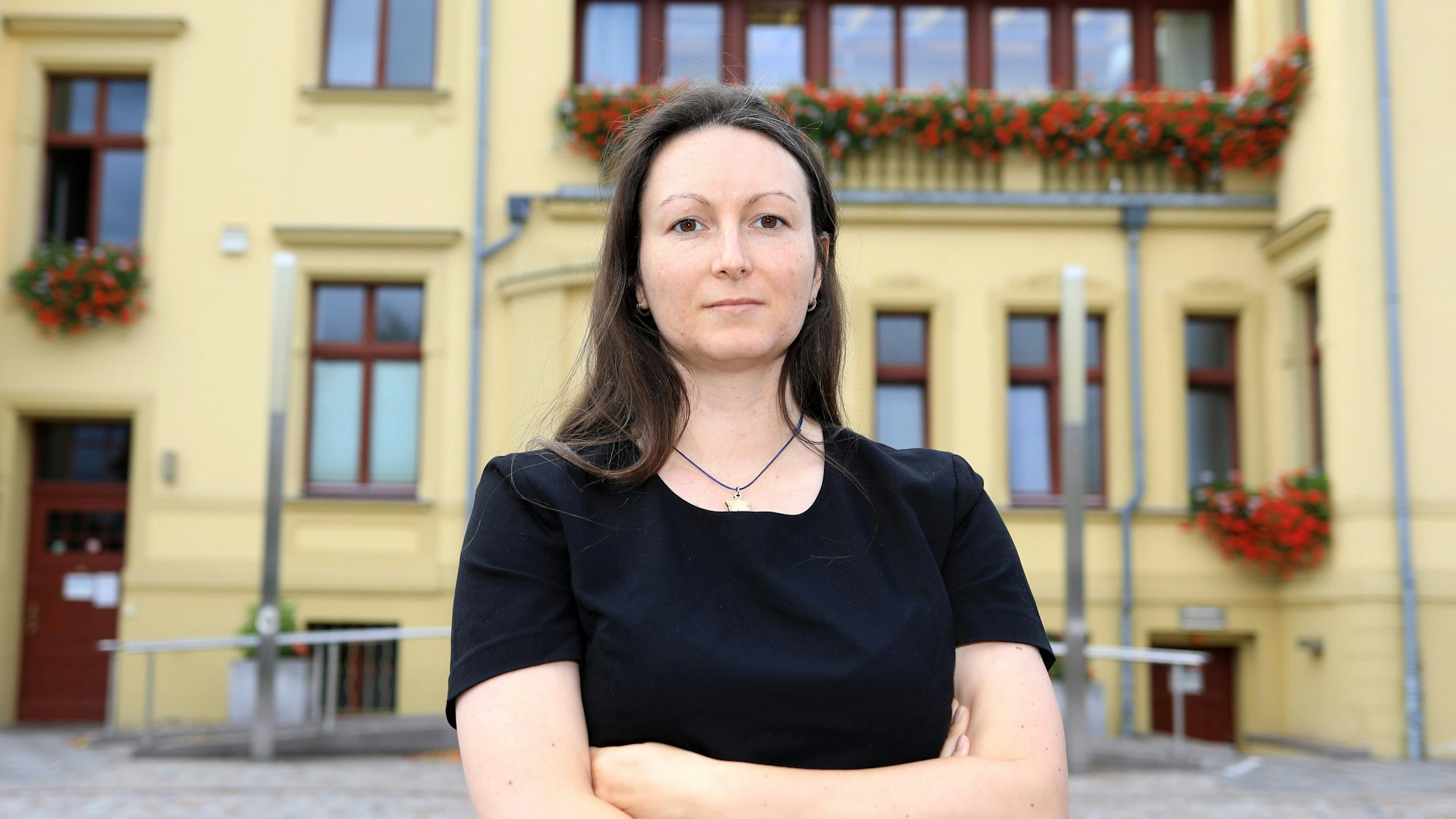 Karolin Braunsberger-Reinhold (CDU) steht vor einem gelben Gebäude.
