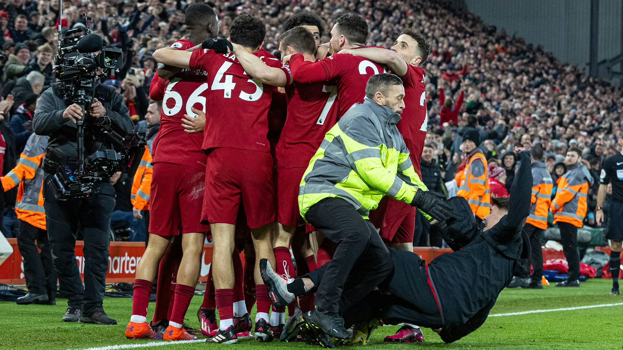 Die Spieler von Liverpool jubeln, ein Flitzer rutscht in die Gruppe.