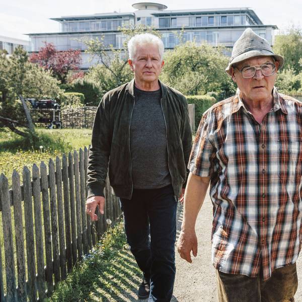 Ivo Batic (Miroslav Nemec, links) und Franz Leitmayr (Udo Wachtveitl, rechts) gehen mit dem Verdächtigen Hackl (Burghart Klaußner) durch eine Kleingartensiedlung. Batic und Leitmeyr schauen ernst, fast genervt. Hackl sieht wütend aus und geht vor ihnen.