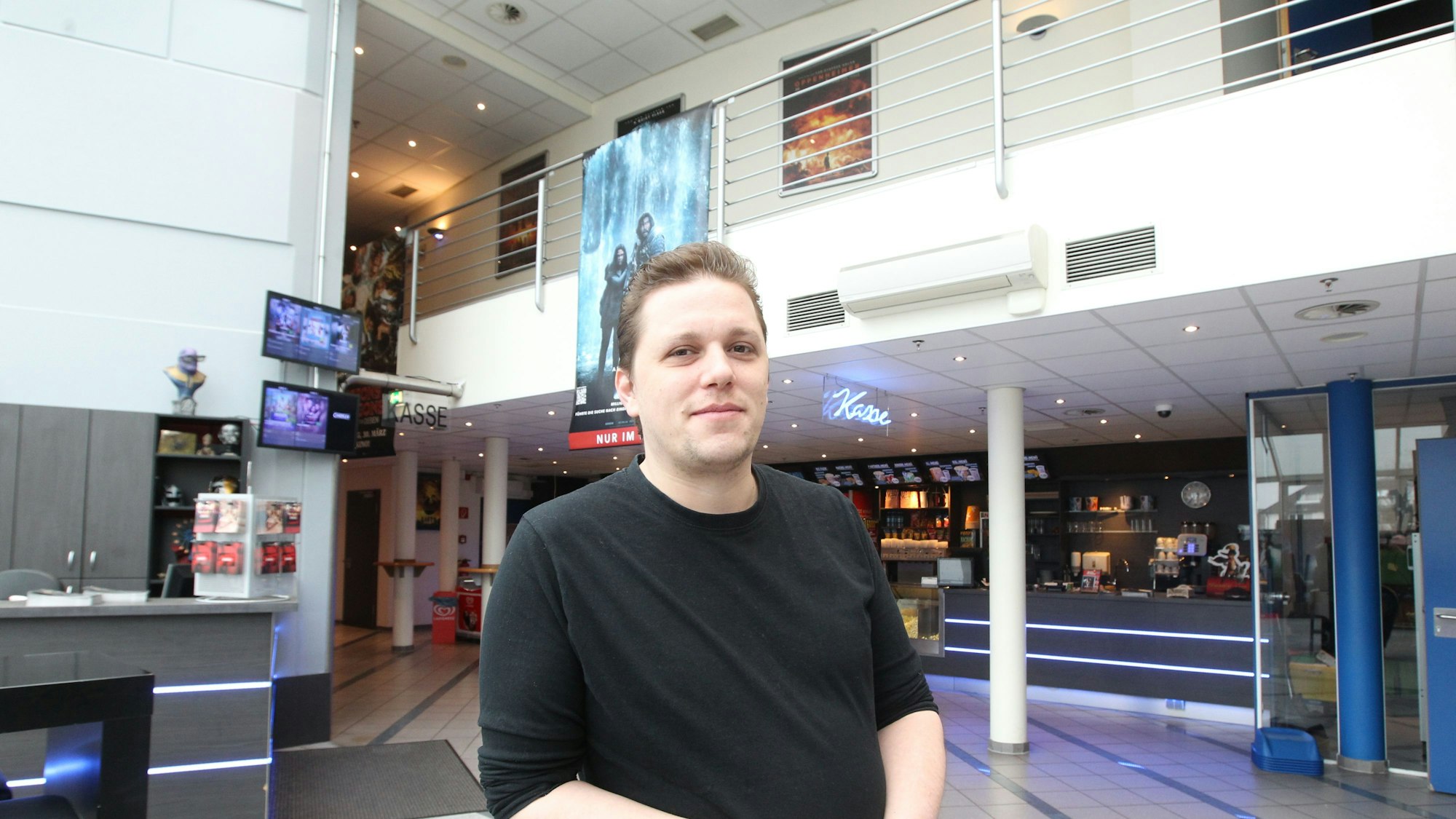 Ein Mann steht im Innenraum eines Kinos.