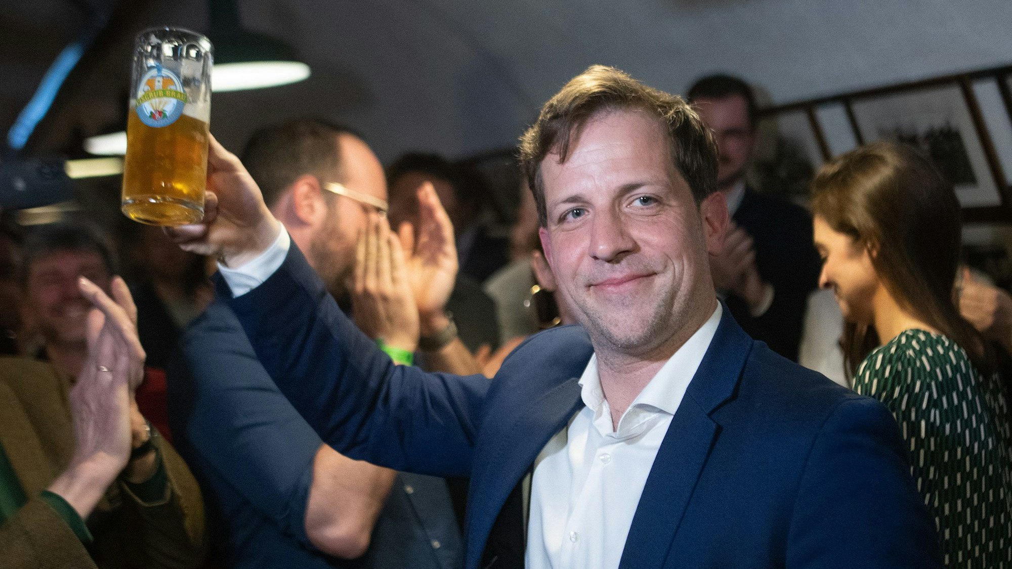 Nino Haase, unabhängiger Kandidat für die Oberbürgermeister-Wahl in Mainz, freut sich mit einem Bier.