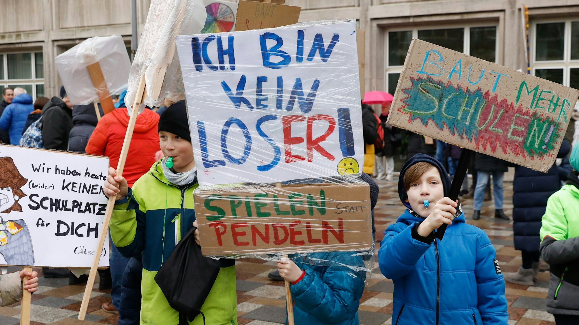 Kinder halten Schilder in der Hand.