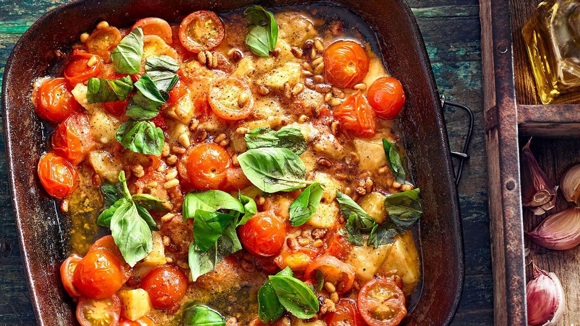 Gericht mit Tomaten und Basilikum in einer Pfanne