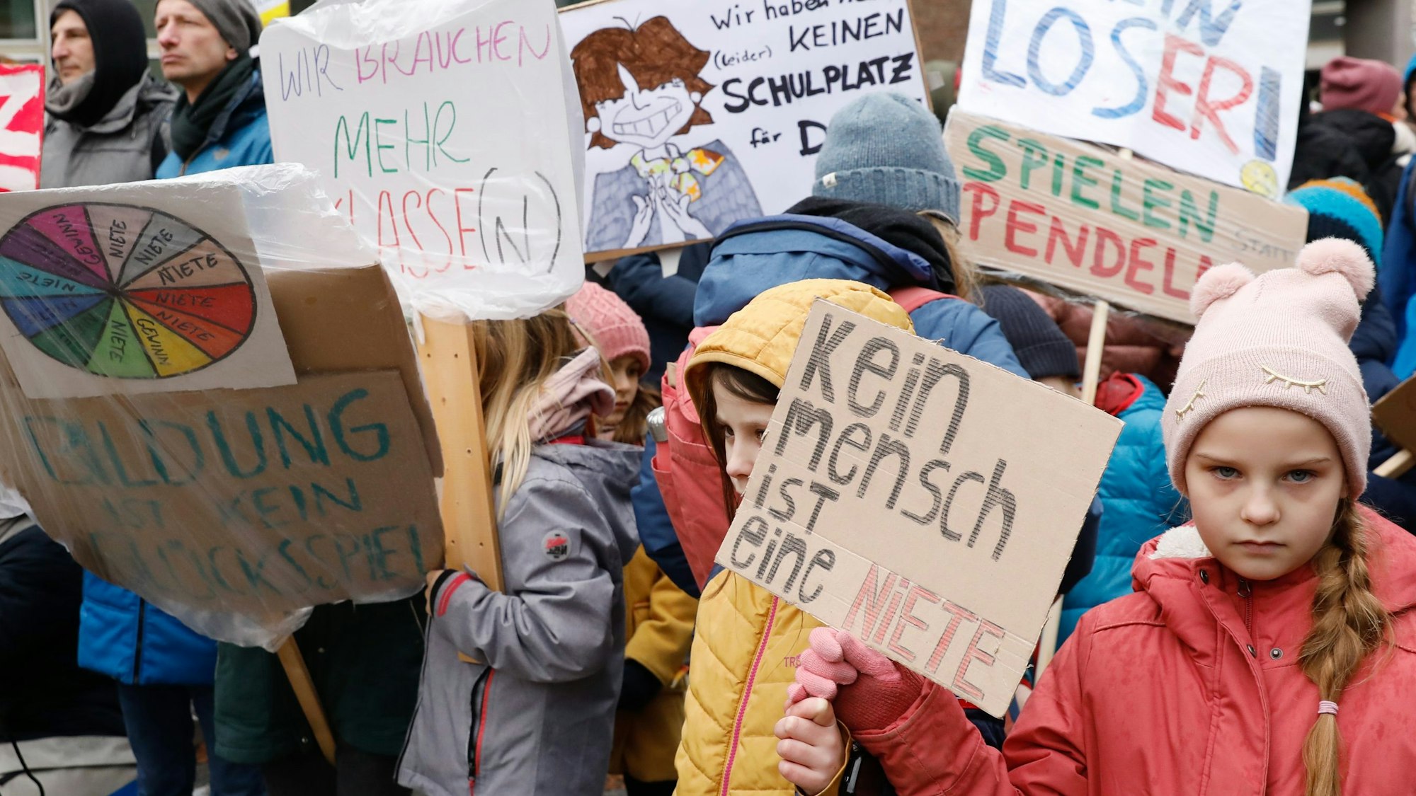 Kinder halten bunte Schilder in der Hand.