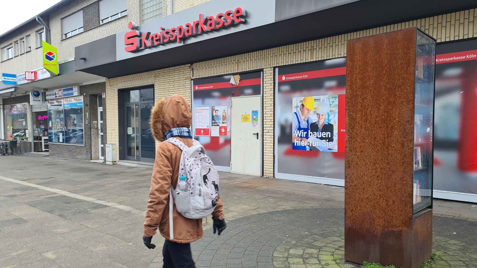Eine Fußgängerin geht an der geschlossenen KSK-Filiale in Kaster vorbei.