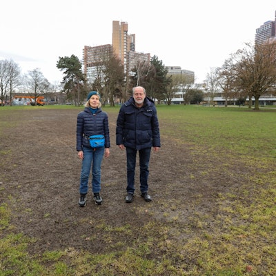 Anwohnerin Aleke Schücking und Helmut Röscheisen vom BUND stehen auf einer ramponierten Wiese im Grüngürtel