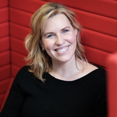 Porträt von Nicole Staudinger in rotem Sessel