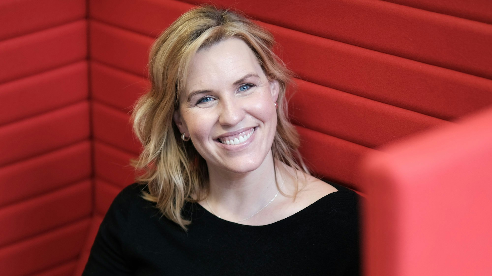 Porträt von Nicole Staudinger in rotem Sessel