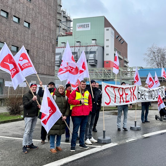 Vor Tor 4 des Chempark Leverkusen haben sich Warnstreikende von Indulor versammelt.