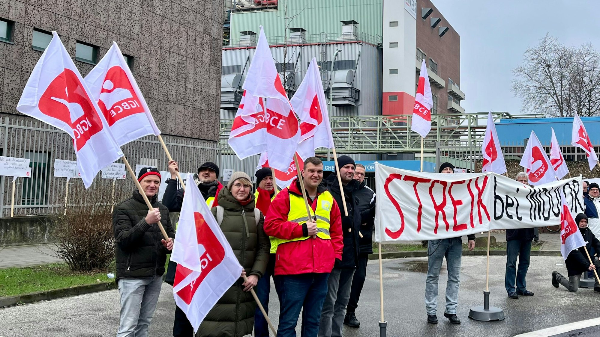 Vor Tor 4 des Chempark Leverkusen haben sich Warnstreikende von Indulor versammelt.