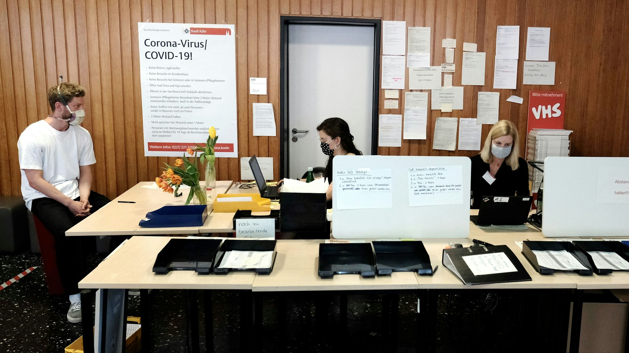 Das Bild zeigt drei Mitarbeiter im Kölner Gesundheitsamt im Jahr 2020.