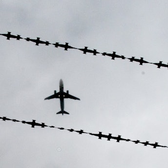 Ein Flugzeug ist hinter Stacheldraht zu sehen.