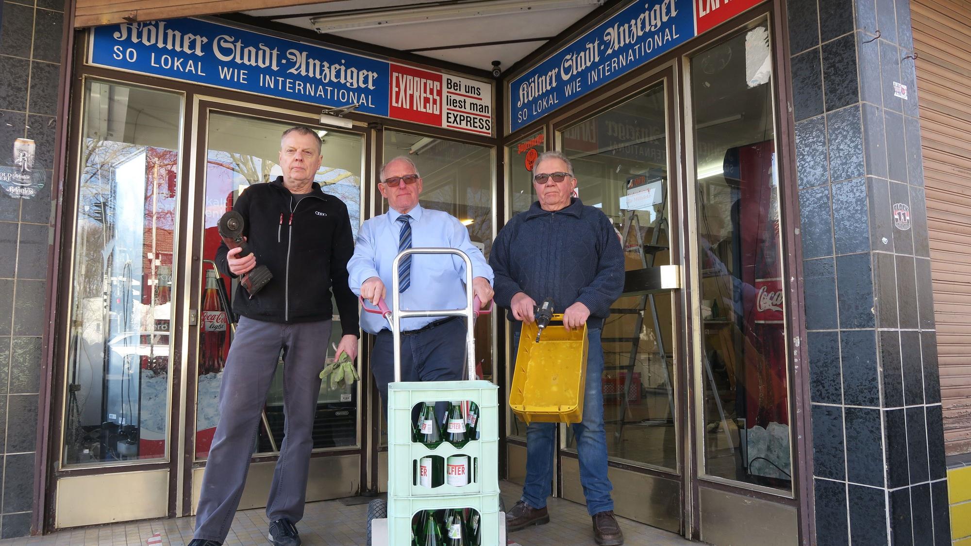 Hans-Joachim Grebe, Gottfried Schneider und Klaus Bensch stehen vor dem Laden mit einer Sackkarre.