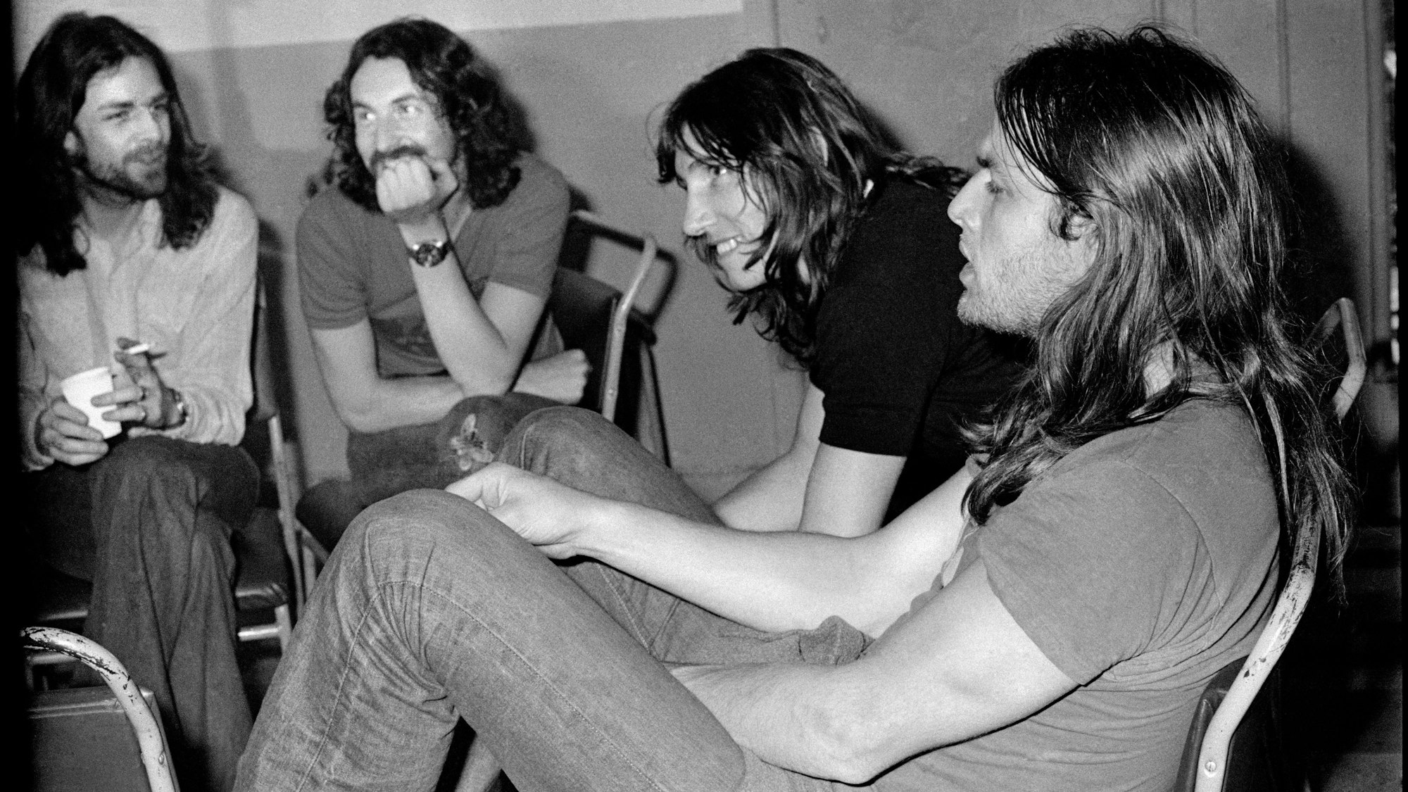 Die Band Pink Floyd im Jahr 1973: Richard Wright (v.l.), Nick Mason, Roger Waters und David Gilmour sitzen im Halbkreis und diskutieren.