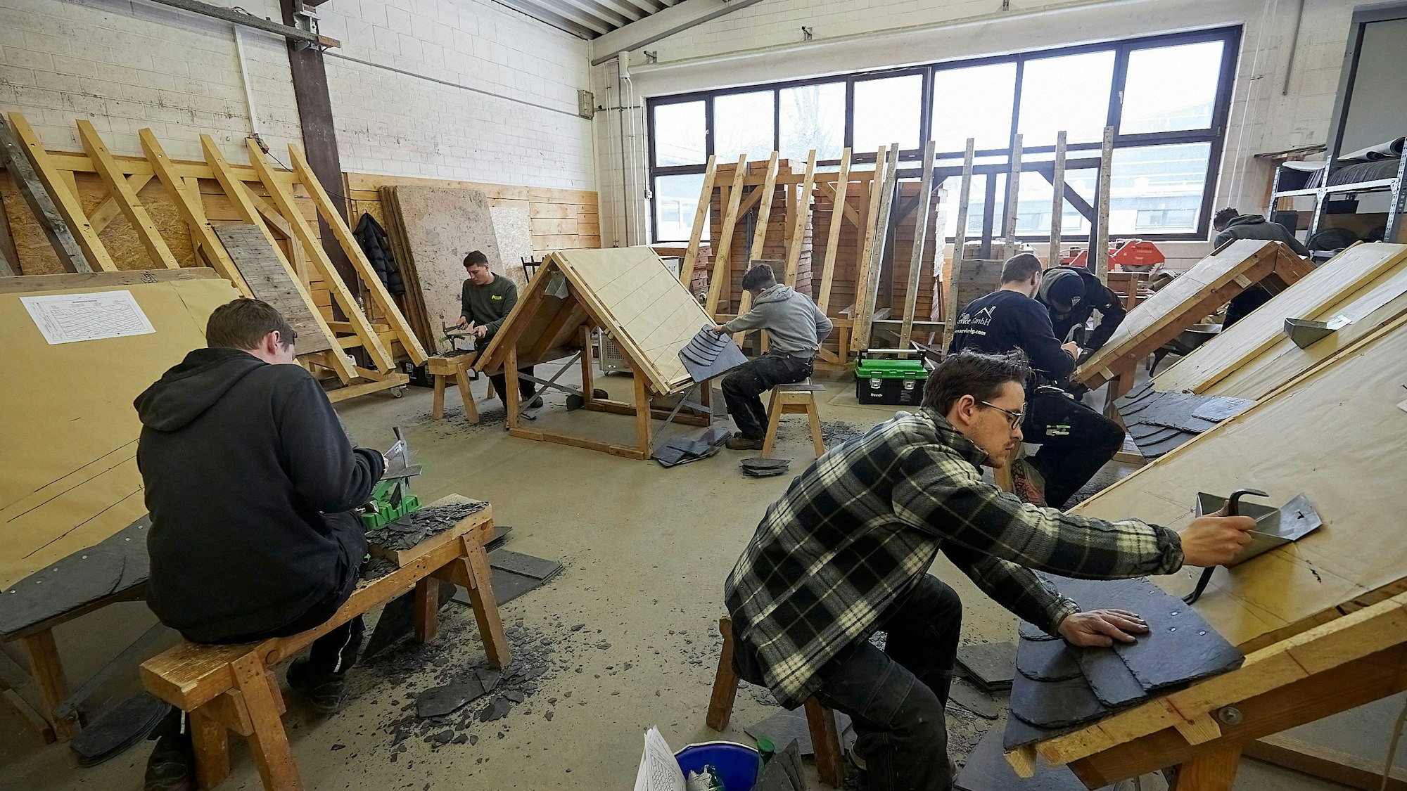 Dachdeckerlehrlinge im dritten Lehrjahr lernen den Umgang mit Schiefer.