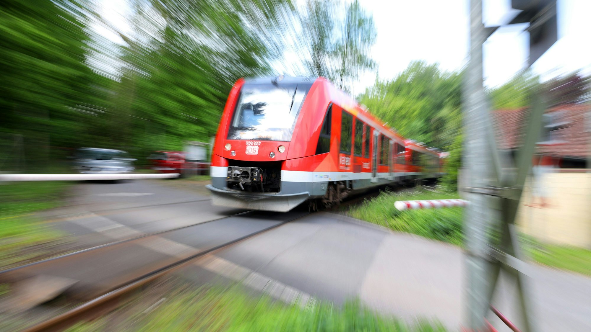 Die Regionalbahn 25 an einem Bahnübergang.