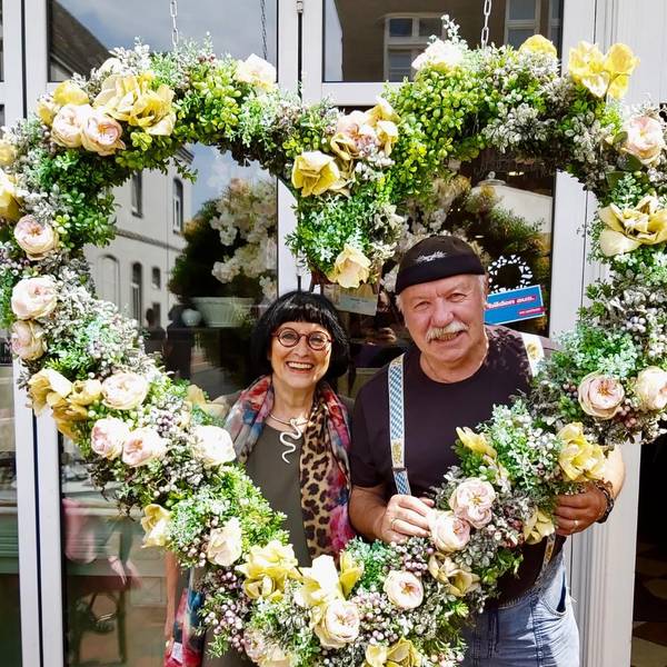 Geschi und Klaus Ridder mit einem großen Herz aus Blumen.