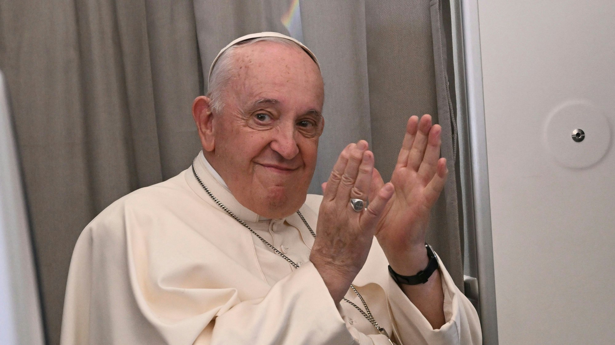 Papst Franziskus klatscht im Februar 2023 während einer Pressekonferenz an Bord eines Flugzeugs, das nach Rom fliegt.