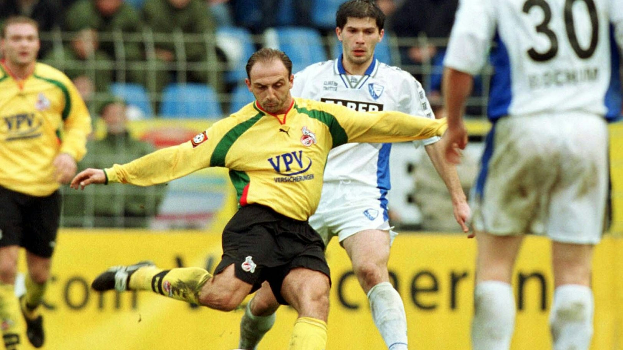 Ein Spieler holt aus zum Torschuss, während zwei Verteidiger nicht mehr eingreifen können.