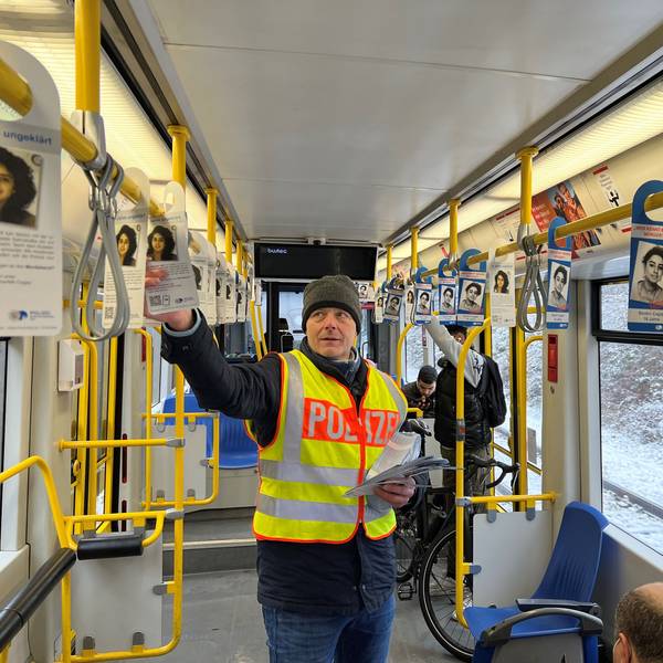 Kriminalhauptkommissar Ulrich Riepelmeier hängt Zettel mit Fahndungsaufrufen zum Cold Case Seckin Caglar in einer KVB-Bahn der Linie 7 auf.