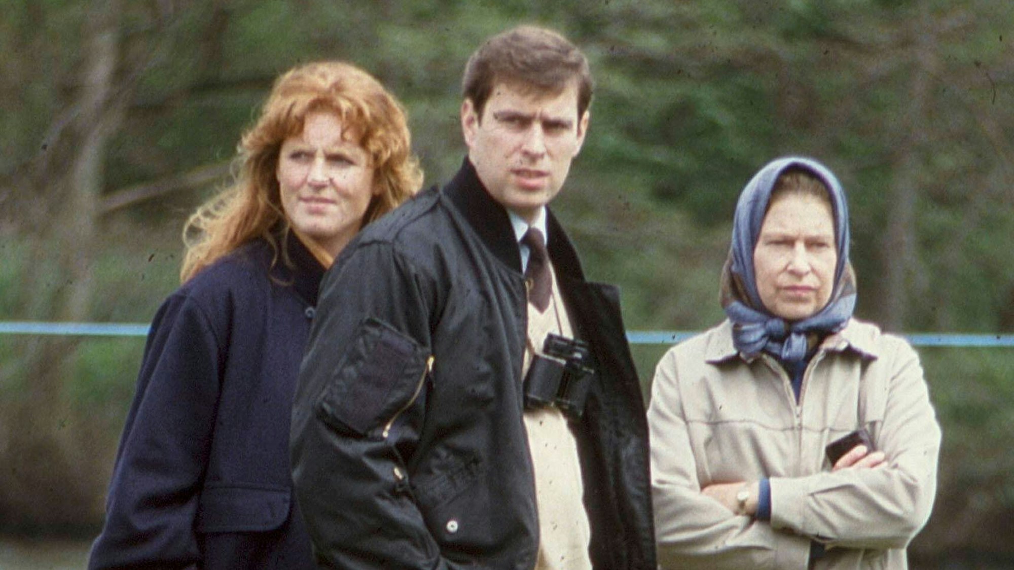 Sarah Ferguson, Prinz Andrew und Königin Elizabeth II. stehen draußen auf einer Wiese.