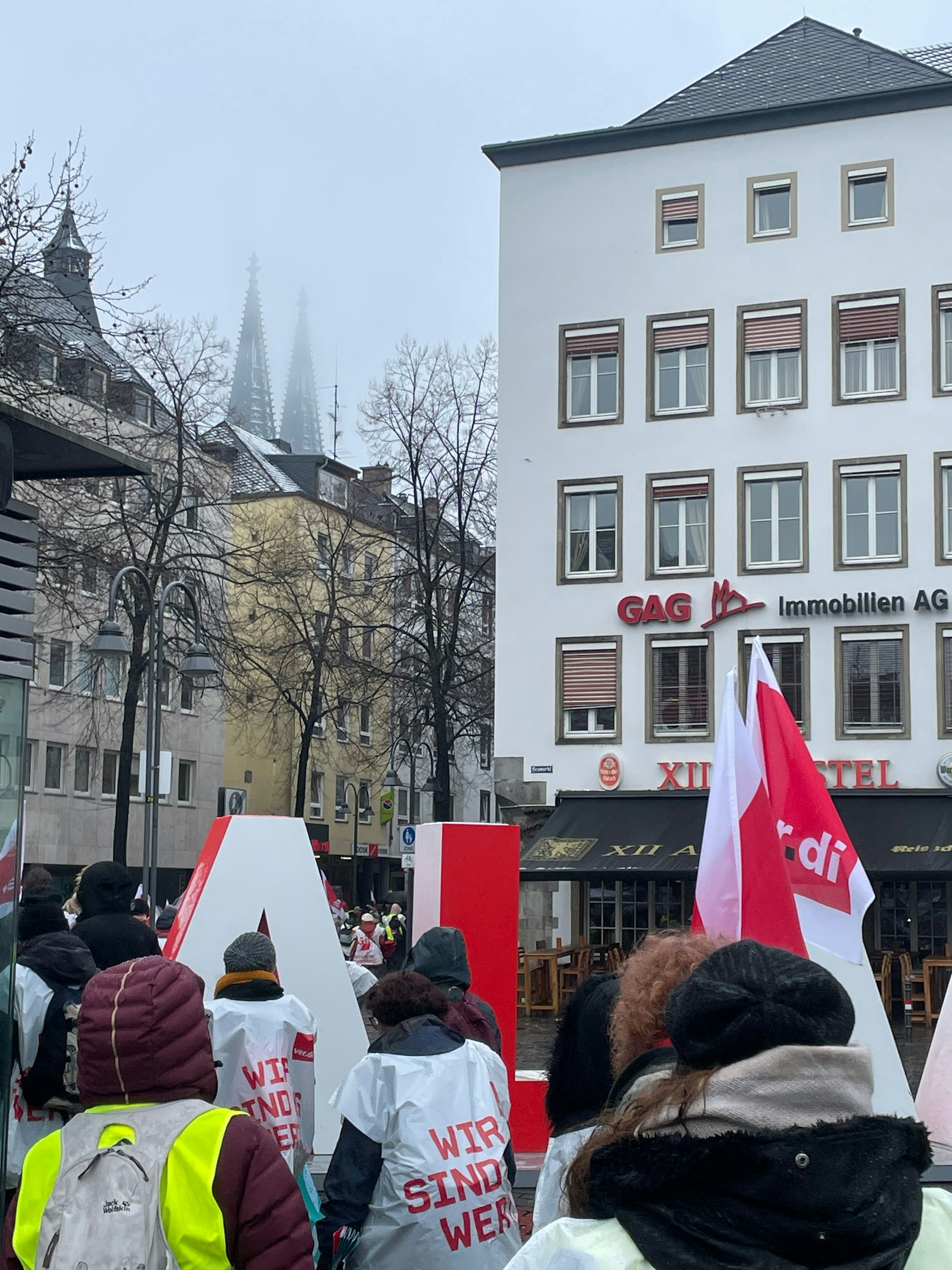 Am Heumarkt ragen die verschneiten Domspitzen hervor, während der Demozug in Richtung Alter Markt läuft.