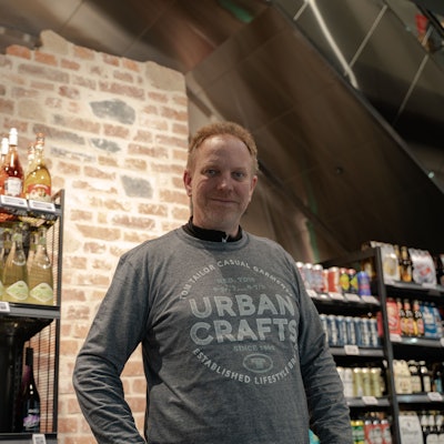 Filialleiter Markus Kelterbaum vor einem Teil der historischen Kölner Stadtmauer.