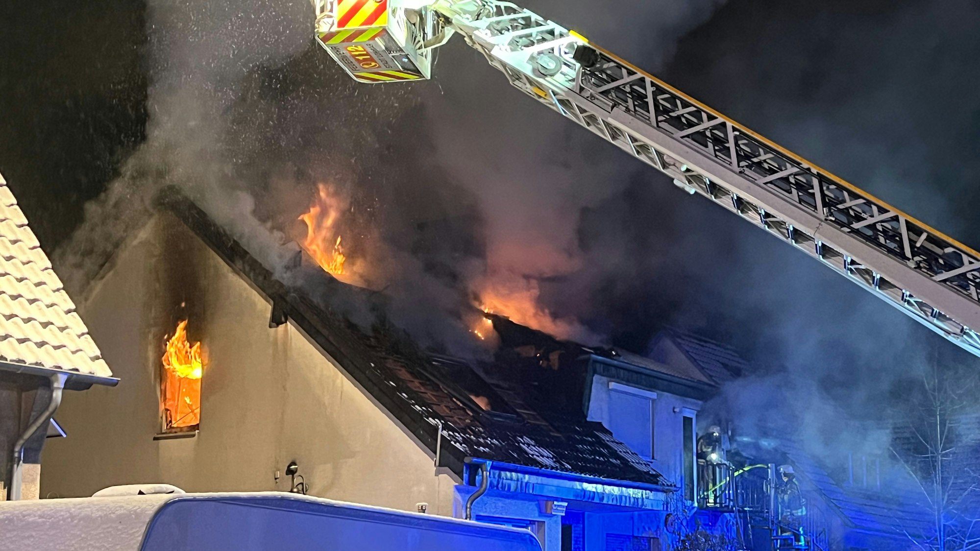 Feuer kommt aus den Fenstern im oberen Stockwerk eines Hauses