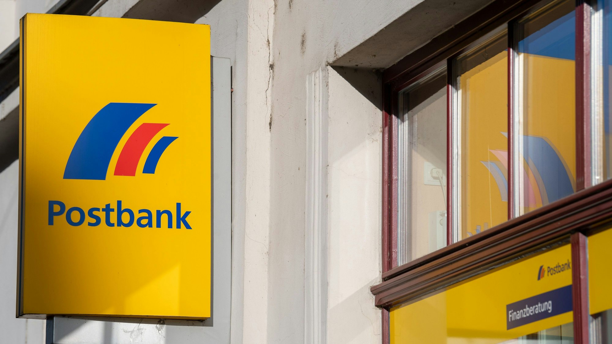 ARCHIV - 25.03.2019, Brandenburg an der Havel: Ein Schild mit dem Logo der Postbank ist an der Fassade einer Bankfiliale angebracht. Jahre nach der Komplettübernahme der Postbank durch die Deutsche Bank beschäftigen Nachforderungen von Aktionären noch einmal den Bundesgerichtshof (BGH). (zu dpa "Frühere Postbank-Aktionäre und Deutsche Bank streiten vor dem BGH") Foto: Monika Skolimowska/dpa-Zentralbild/dpa +++ dpa-Bildfunk +++