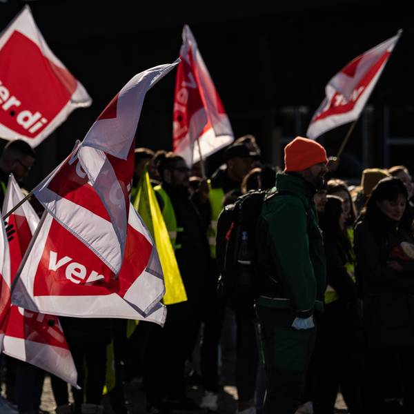 Teilnehmer stehen beim Jugendstreiktag mit Verdi-Fahnen auf einem Platz.