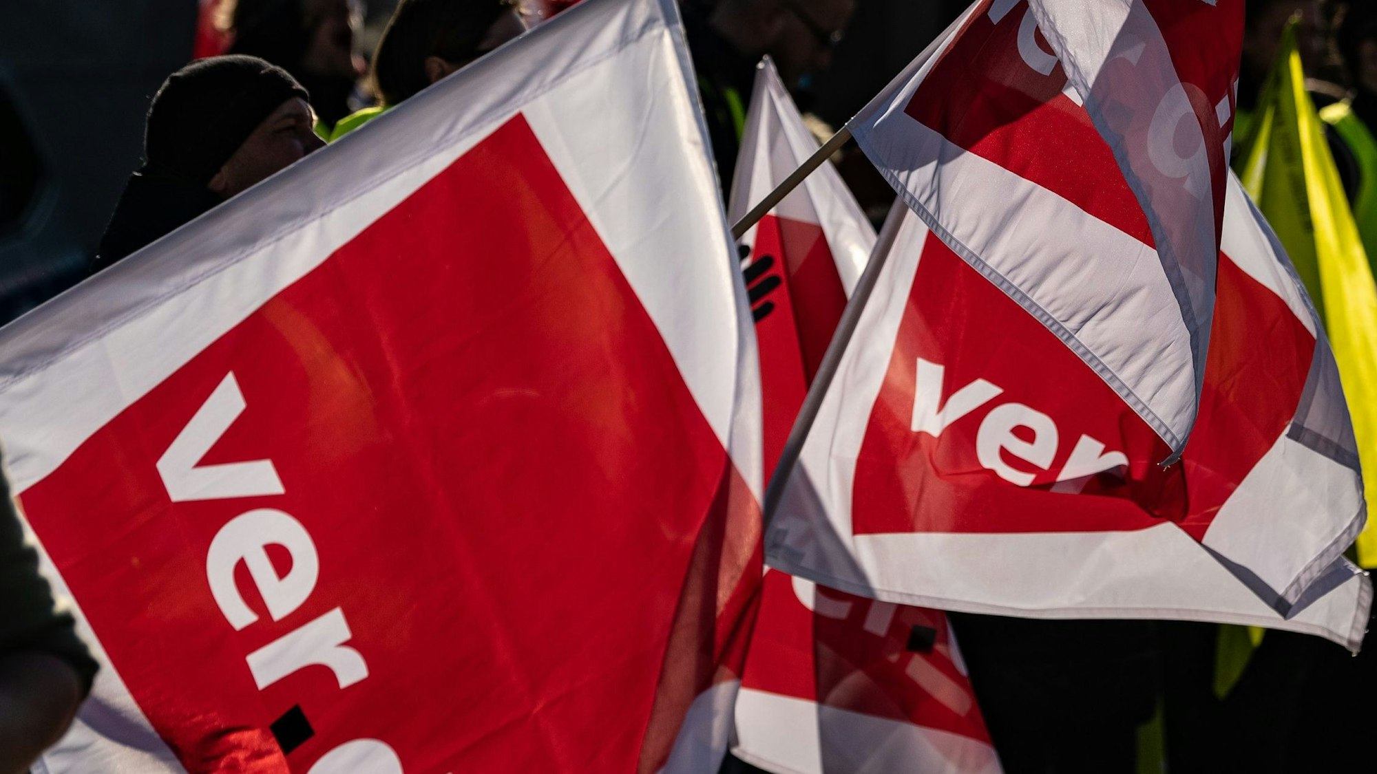 Teilnehmer stehen beim Jugendstreiktag mit Verdi-Fahnen auf einem Platz.