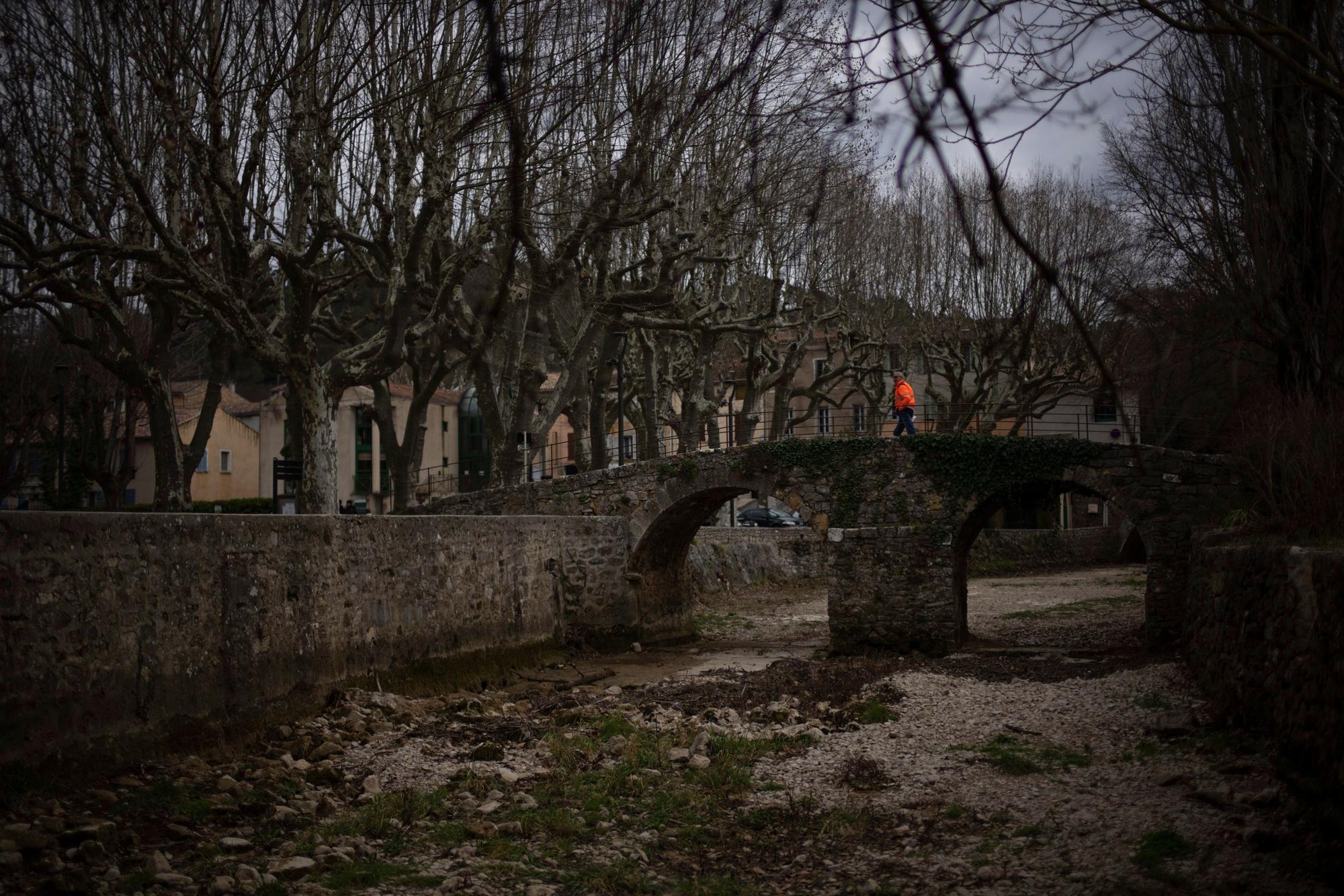 Frankreich, Flassans-sur-Issole: Ein Mann geht über ein ausgetrocknetes Flussbett.
