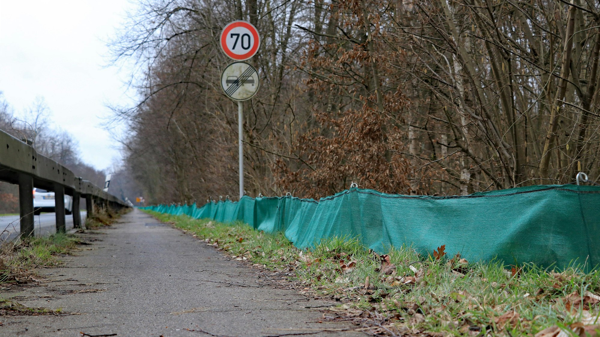 Am Rande der Straße sind dunkelgrüne Planen.
