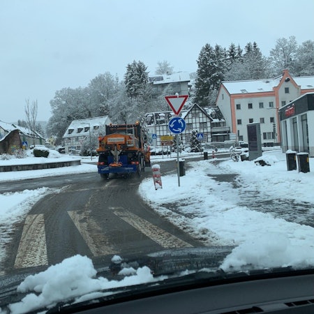 Ein Räumfahrzeug fährt in der Eifel durch einen Kreisverkehr.