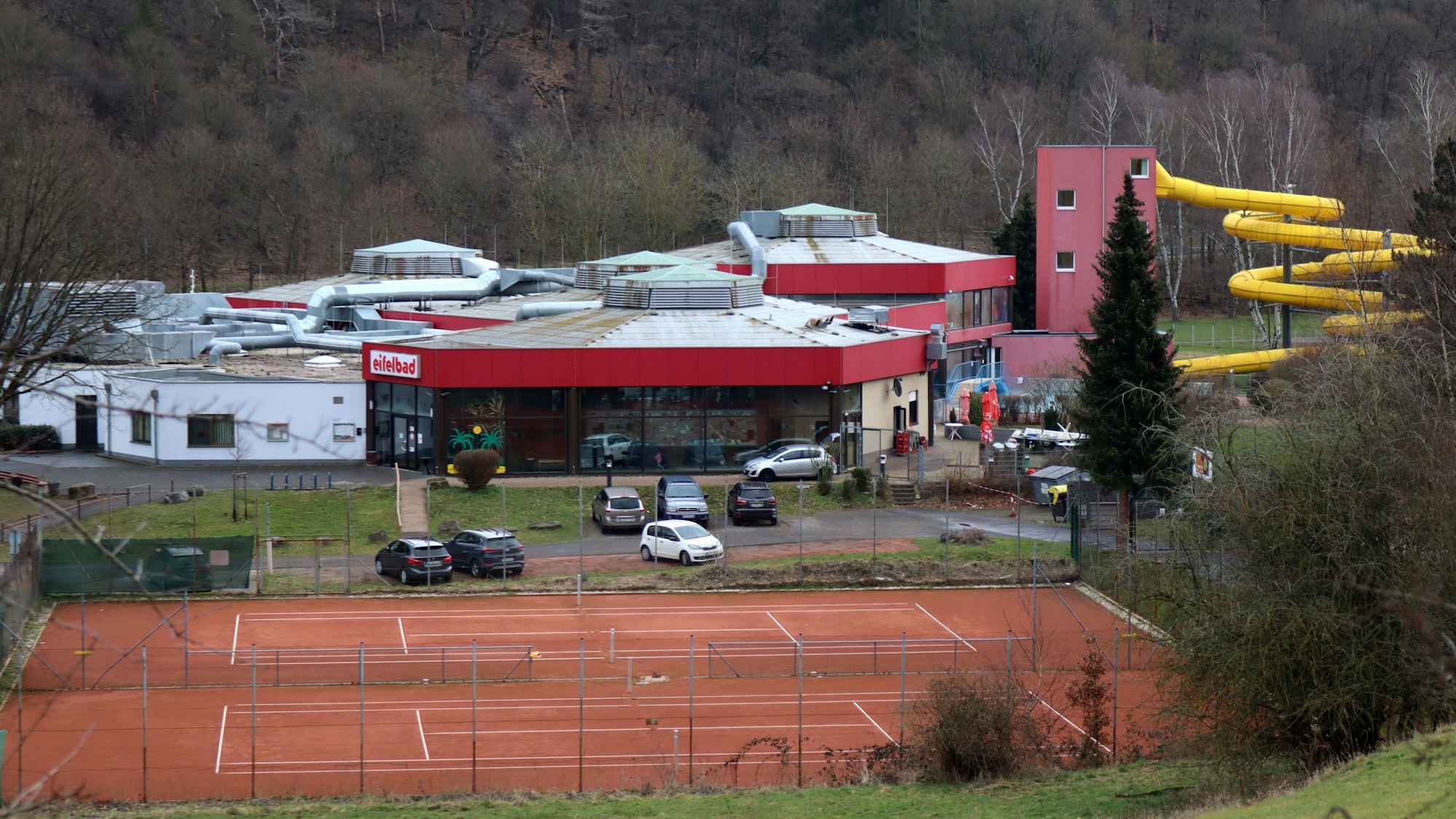 Das Foto zeigt das Eifelbad, im Vordergrund sind Tennisplätze zu sehen.