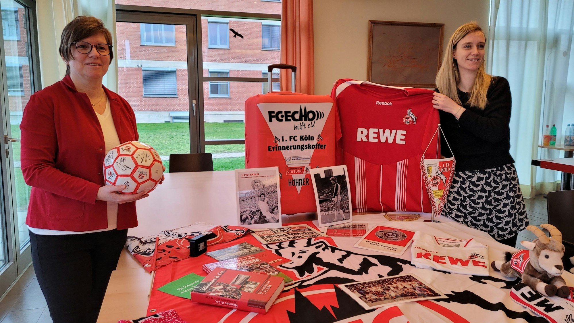 Martina Romeike (l.) und Nadine Diederich-Cujai mit verschiedenen Fan-Utensilien.