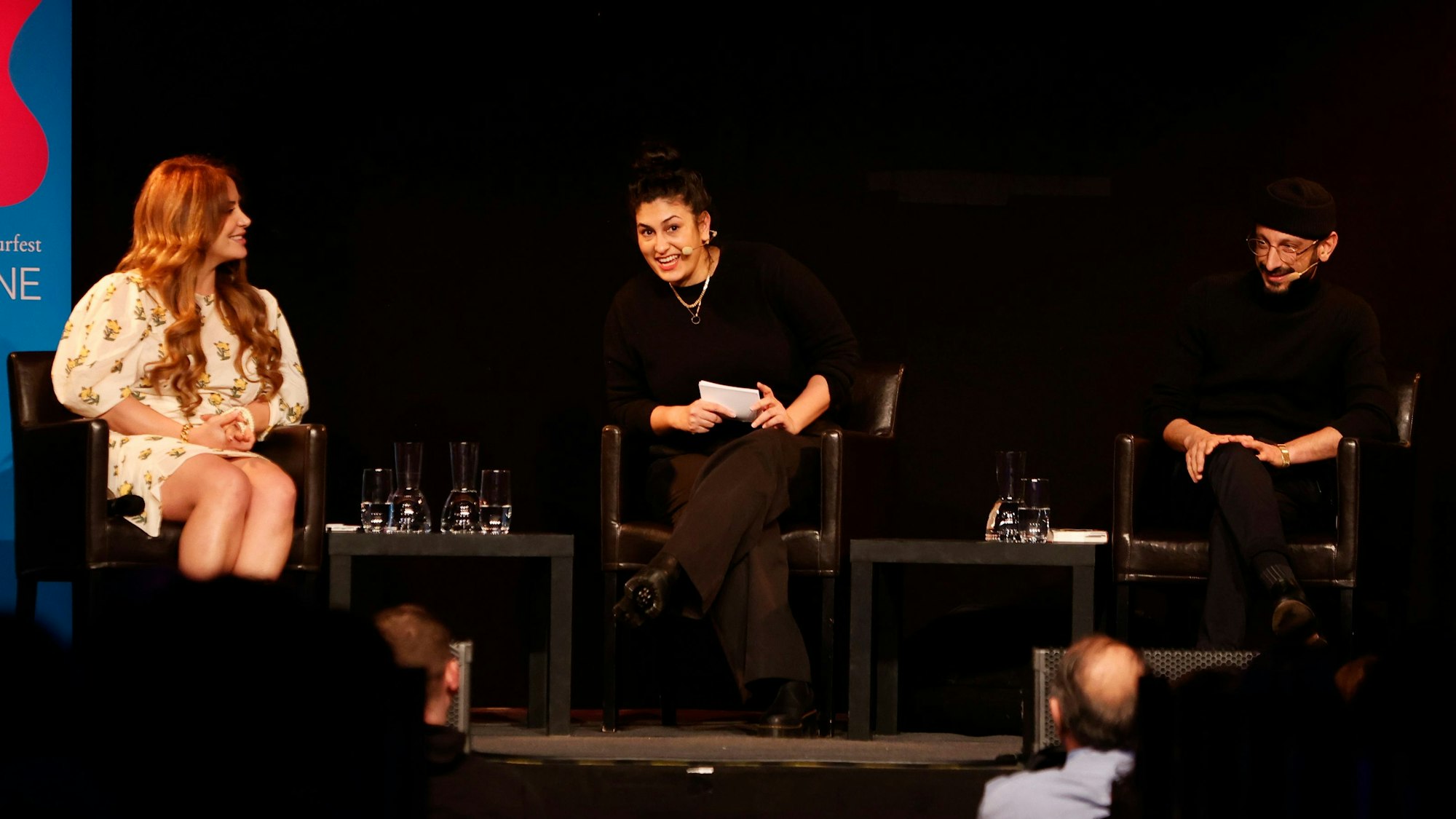 Enissa Amani (links), Aida Baghernejad, und Behzad Karim Khanibei sitzen auf der Bühne in der Kulturkirche Köln.