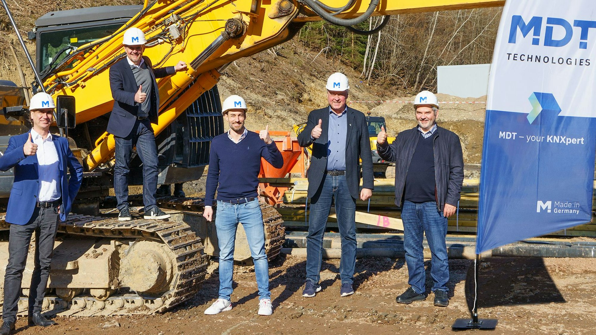 Die MDT-Führungsriege mit Dietrich Bertram, Geschäftsführer Roger Karner, Steffen Hirsch und Hans-Joachim Kremer sowie Bürgermeister Dr. Gero Karthaus vor einem Bagger.