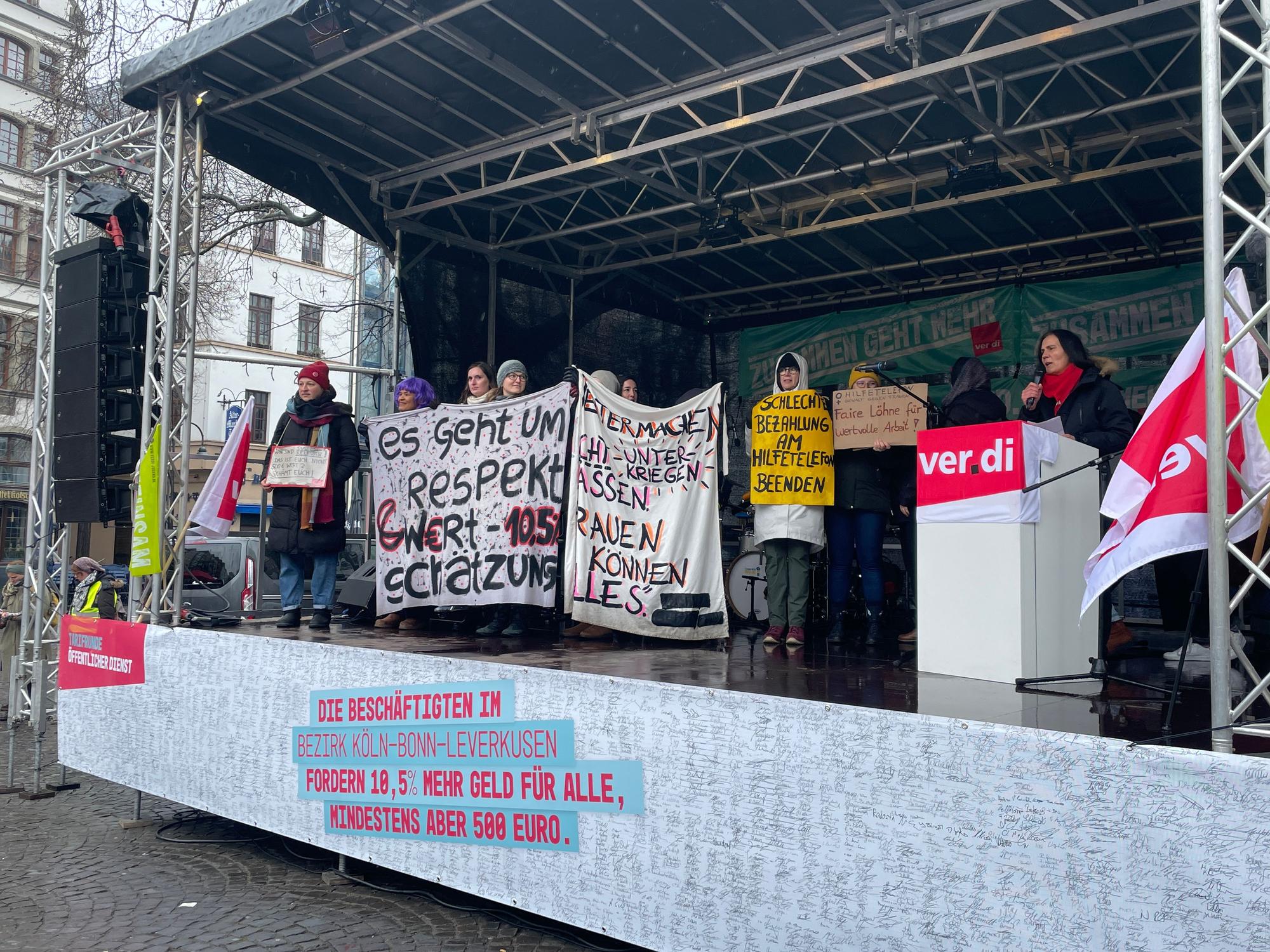 Beraterinnen der Hilfetelefone „Gewalt gegen Frauen“ und „Schwangere in Not“ sprechen auf der Kundgebung des Kita-Streiks auf dem Alter Markt.