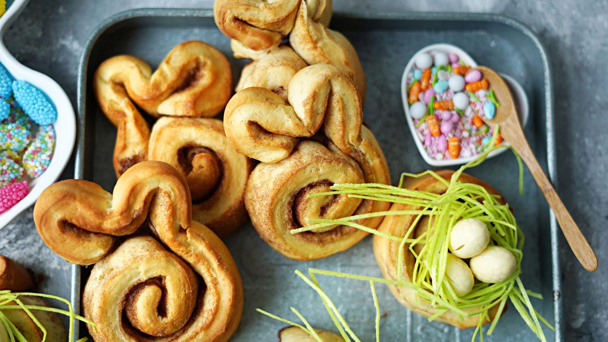 Ein Teil der Zimtschnecken werden als Nester dekoriert, der andere Teil bekommt Hasenohren verpasst.