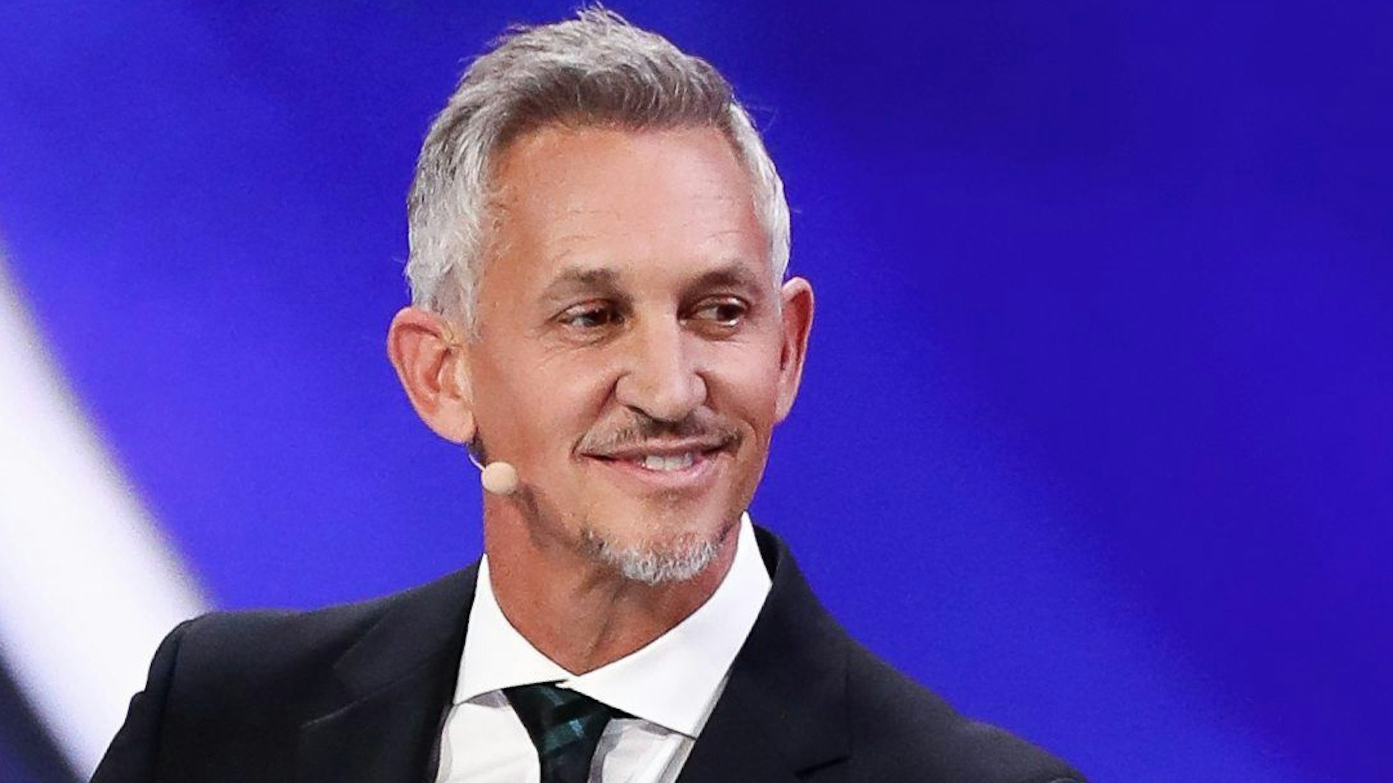 ARCHIV - 01.12.2017, Russland, Moskau: Fußball: Auslosung der Gruppen für die Vorrunde der Fußball-Weltmeisterschaft 2018 am 01.12.2017 im Kremlpalast in Moskau (Russland). Der ehemalige Fußballspieler von England Gary Lineker steht bei der Auslosung auf der Bühne. (zu dpa: «Asylgesetz mit Nazi-Deutschland verglichen - BBC rügt Lineker») Foto: Christian Charisius/dpa +++ dpa-Bildfunk +++